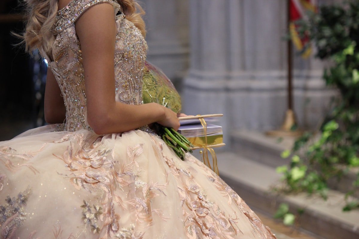 Jovem debutante com vestido de baile segurando buquê de flores para festa de 15 anos