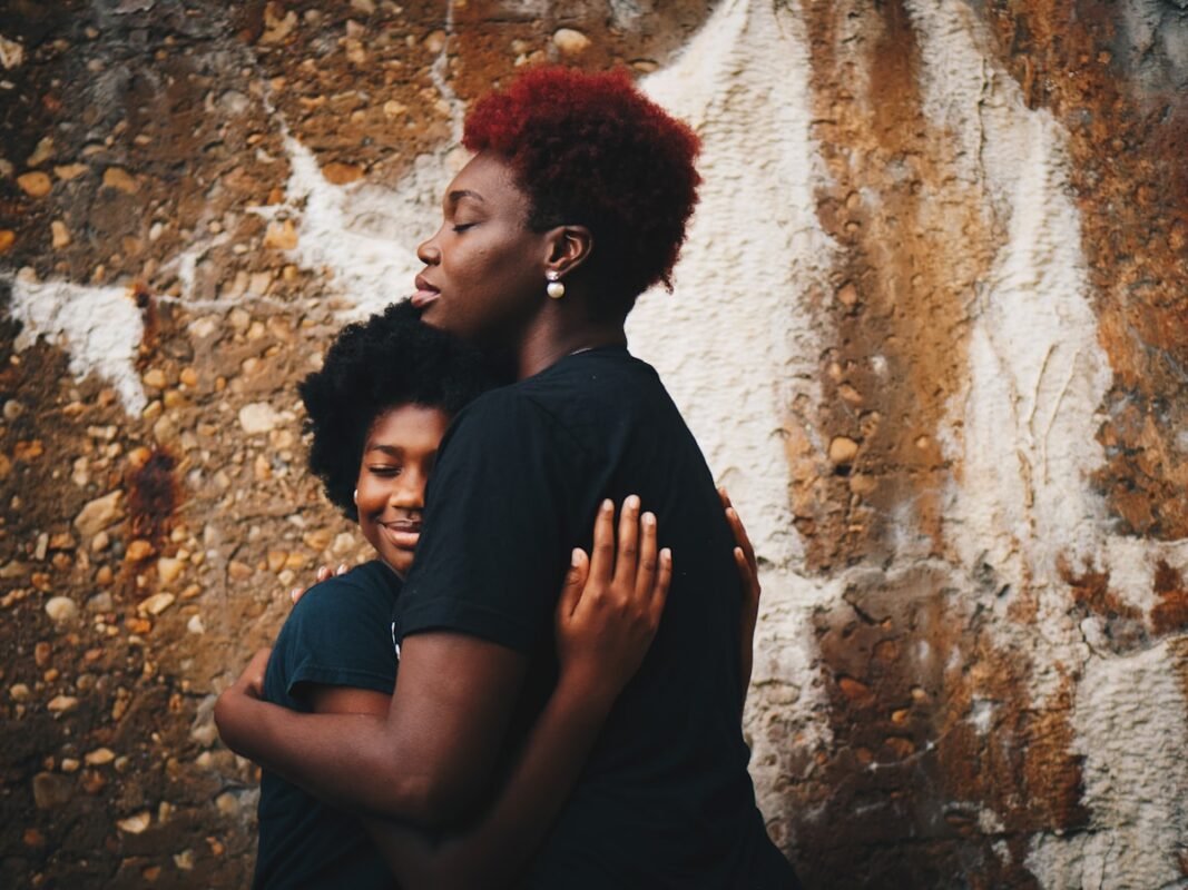 Mãe e filha se abraçando emocionadas na homenagem da festa de 15 anos