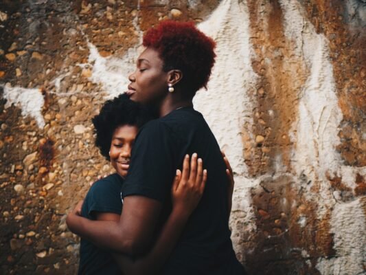 Mãe e filha se abraçando emocionadas na homenagem da festa de 15 anos